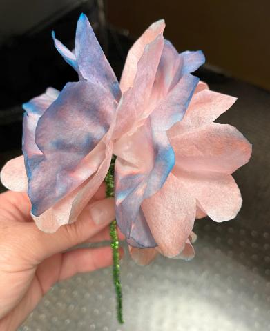 Colored coffee filters held together with a green pipe cleaner