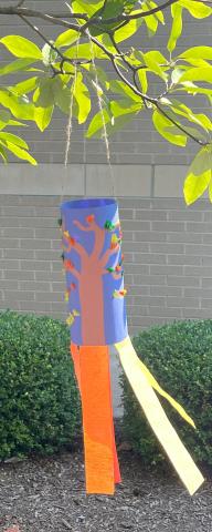 Construction paper with streamers hanging from a tree