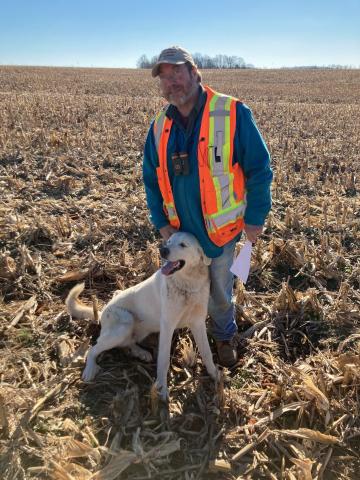 Pat Trader in the field with a dog