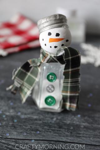 Snowman salt shaker craft made from a salt shaker, with white wooden ball and snowman face, scarf and buttons.