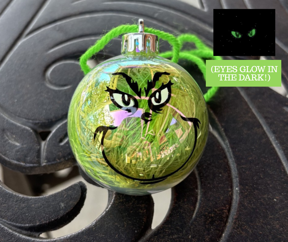 Grinch tree ornament sitting on a table.